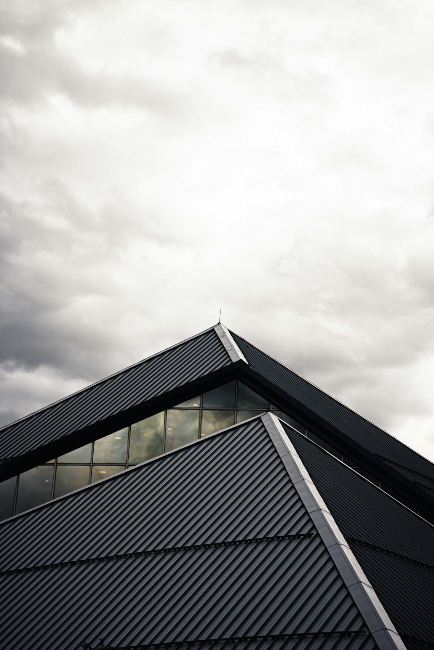 Metal roof apex with skylight under moody sky